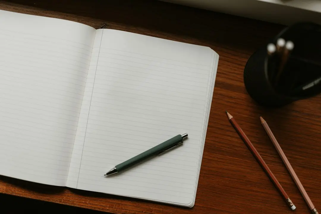 An open lined notebook with a pen and two pencils on a wooden desk, ready for a checklist to compare IPTV services